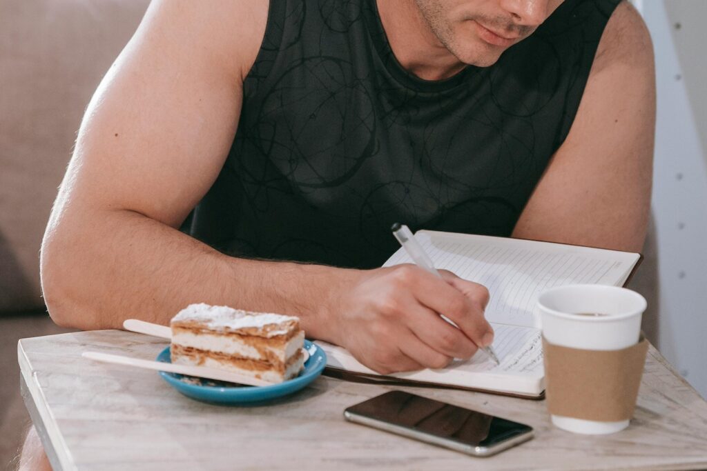 a man sitting in a cafe writing daily journal prompts